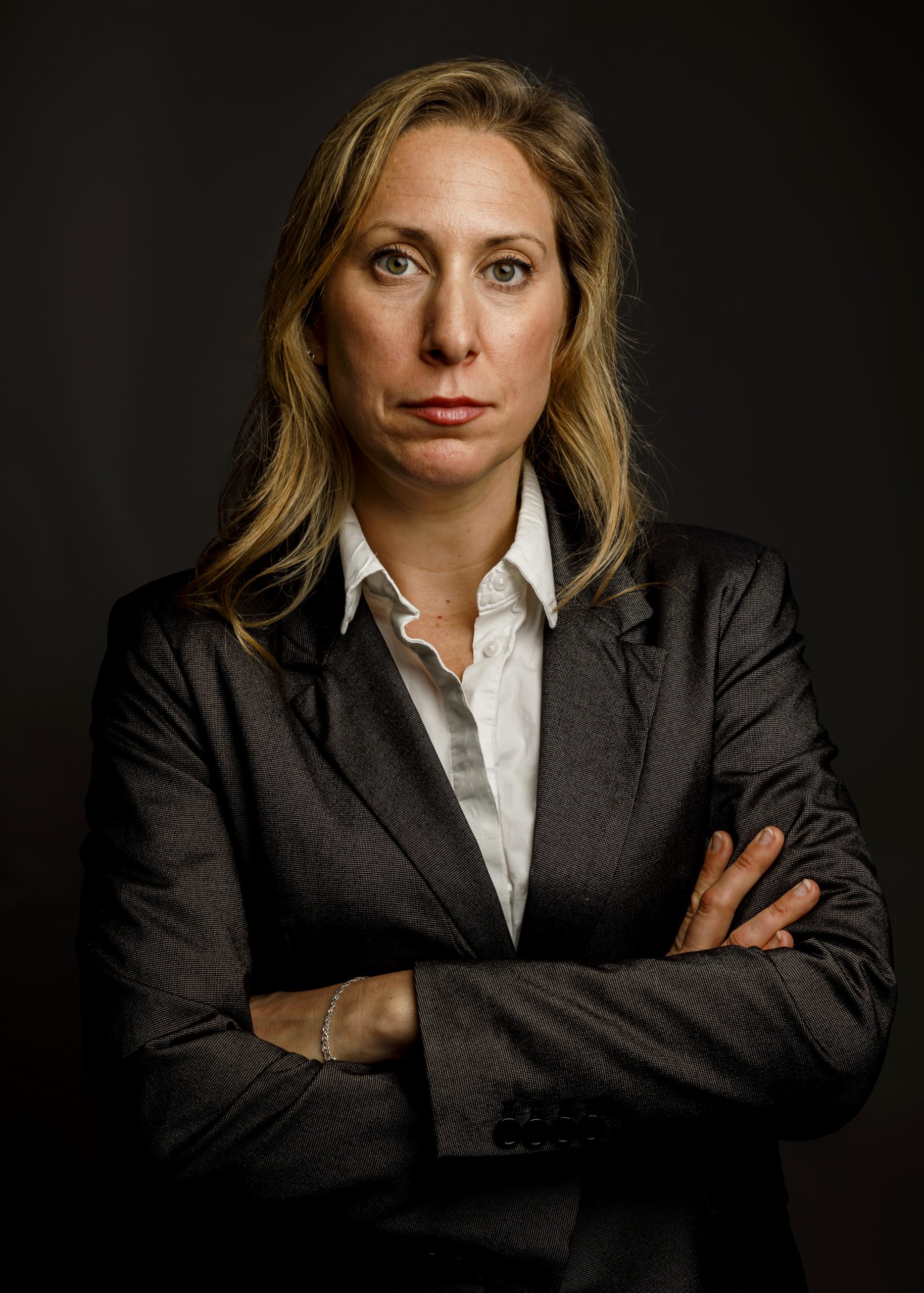 Professional portrait of a woman in a red dress against a glowing orange background, taken by Marcos Appelt Portrait Photographer in Bristol and Southwest.”