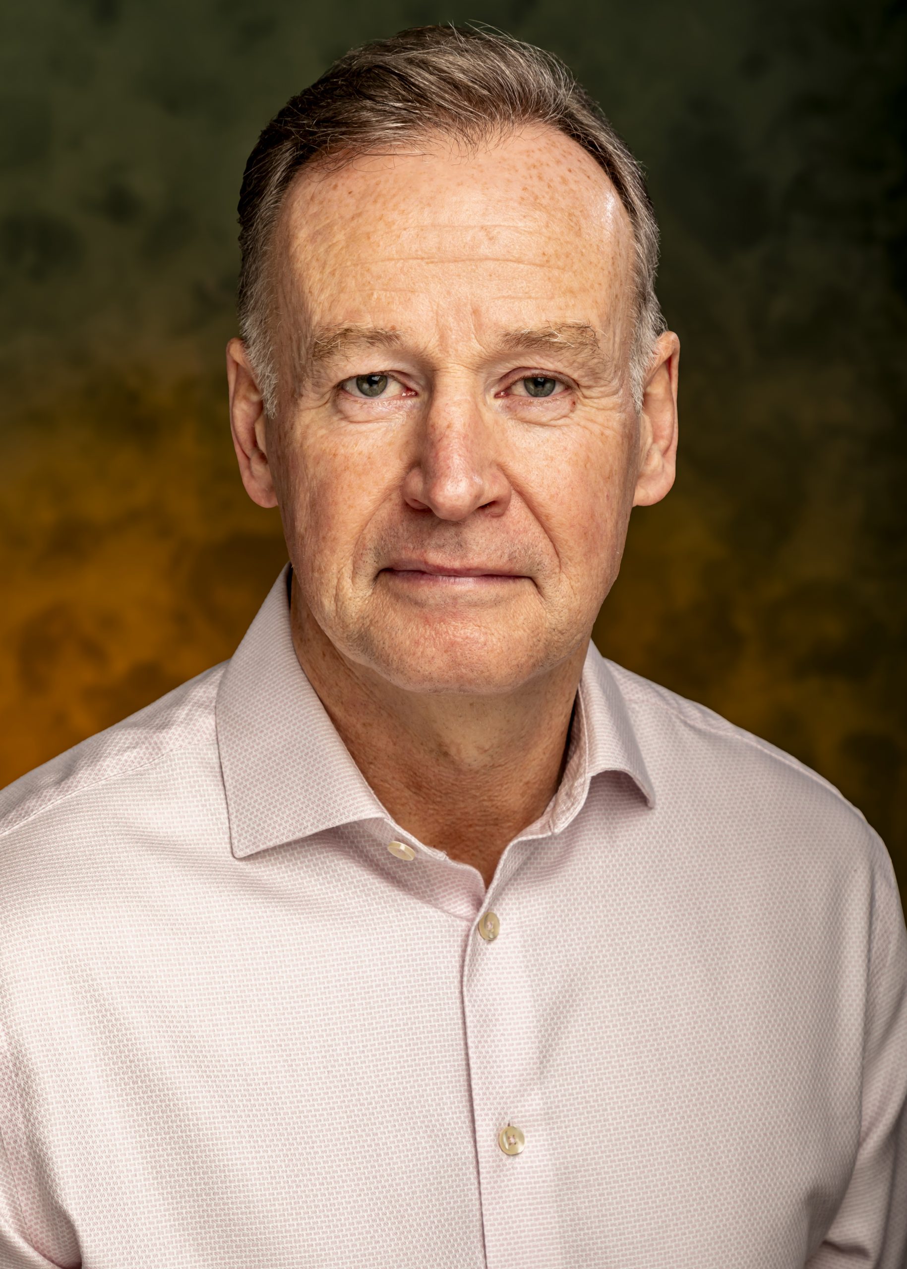 Professional headshot of a middle-aged man in a light shirt against a neutral background, taken by Marcos Appelt Portrait Photographer in Bristol and Southwest.