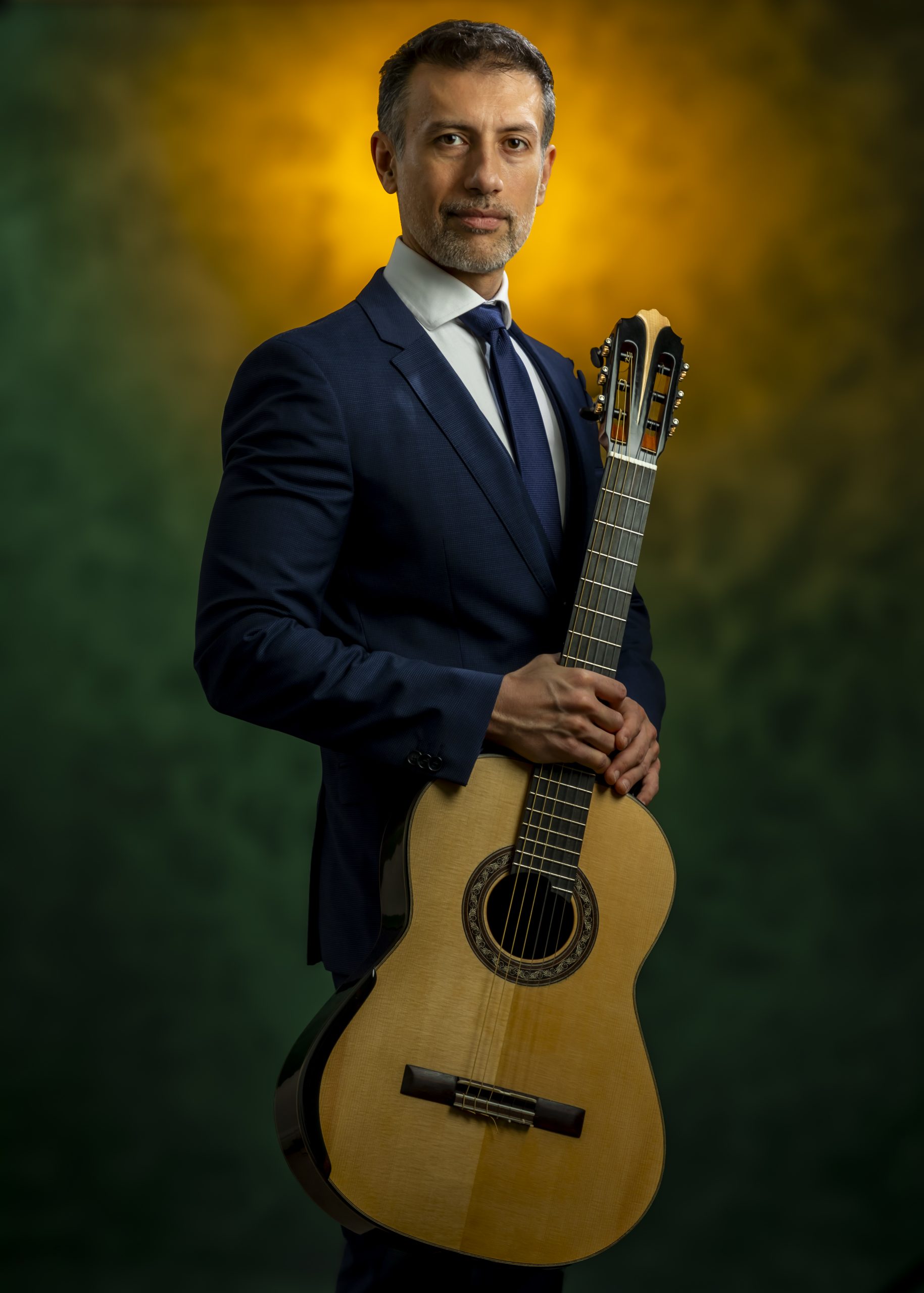 Professional portrait of a woman in a red dress against a glowing orange background, taken by Marcos Appelt Portrait Photographer in Bristol and Southwest.”