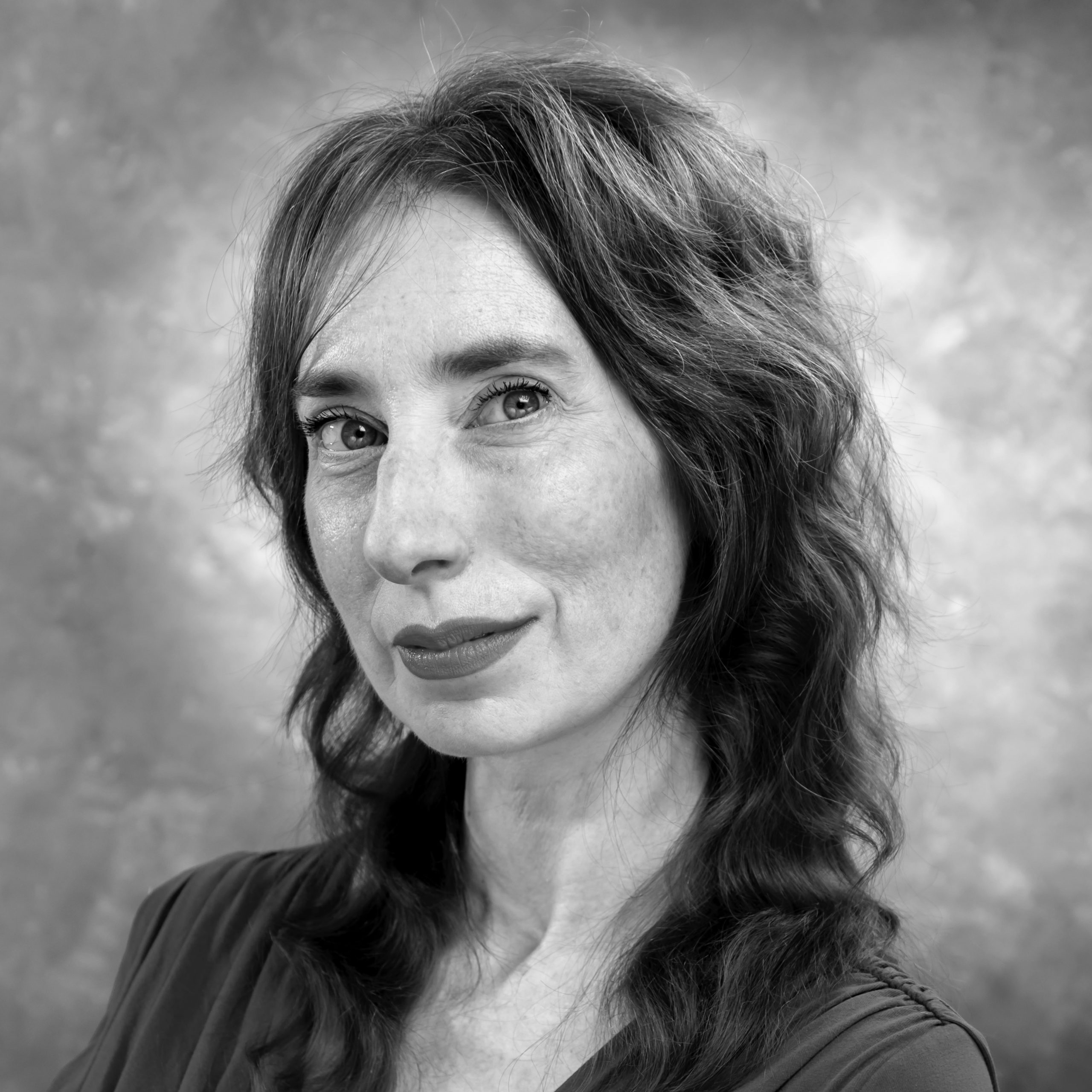 Black-and-white circular portrait of a woman with long wavy hair, wearing a dark top, facing slightly to the side. Positioned next to text that reads ‘Marianna Moralis’ and a short testimonial excerpt.