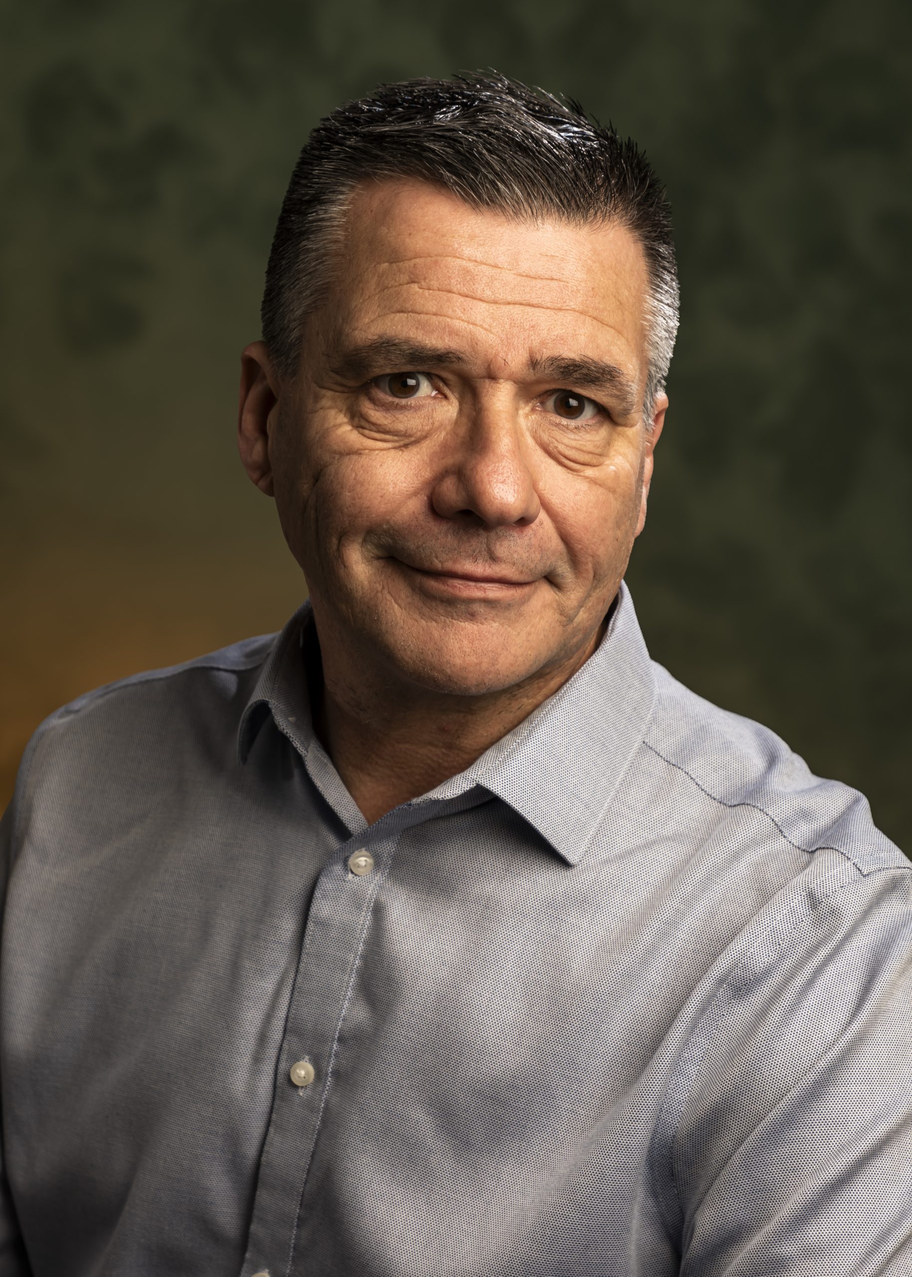 Professional headshot of a middle-aged man in a light shirt against a neutral background, taken by Marcos Appelt Portrait Photographer in Bristol and Southwest.